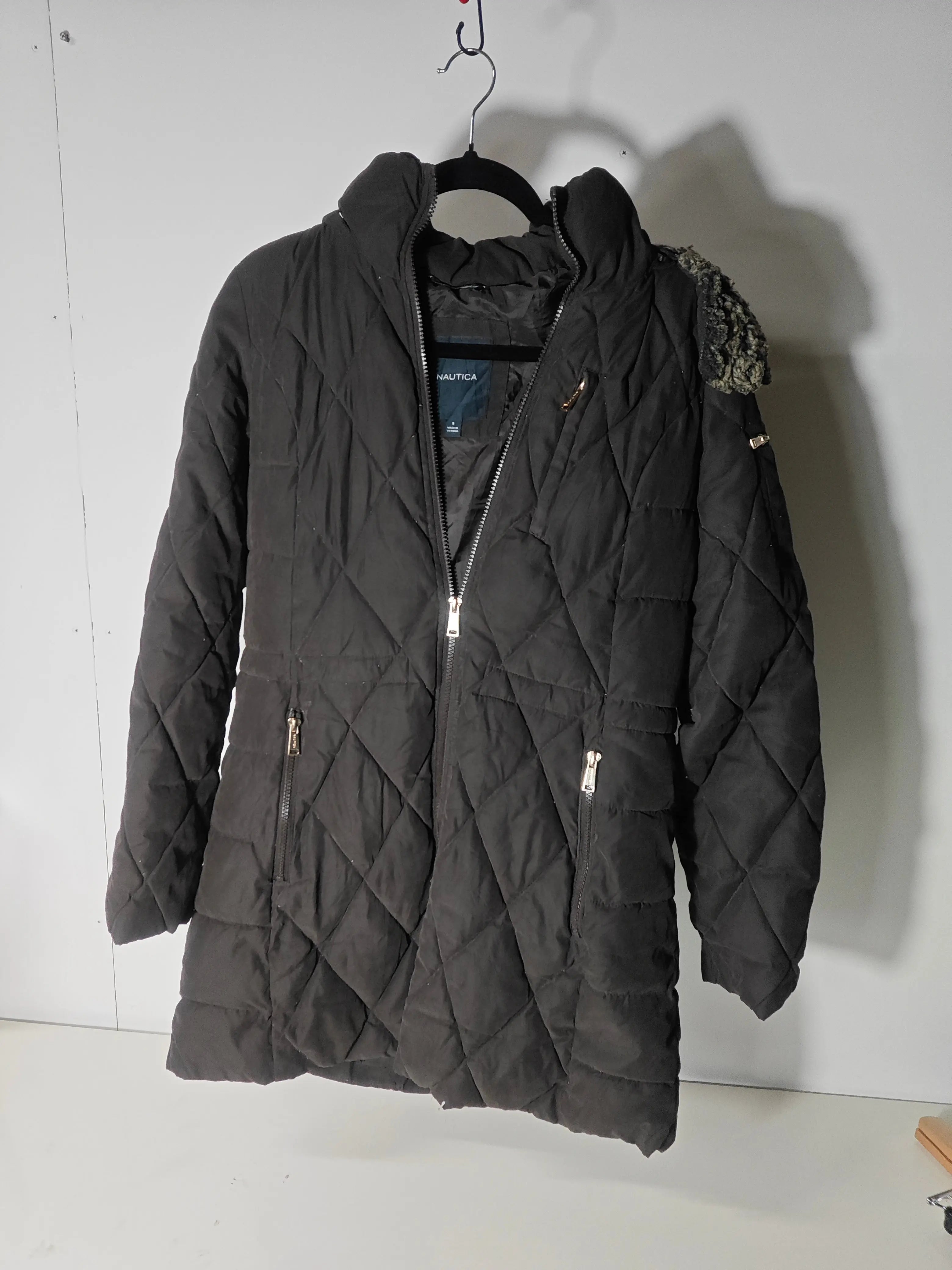 Veste d'hiver noire par Nautica, matelassée avec fermeture éclair et capuche à fausse fourrure.