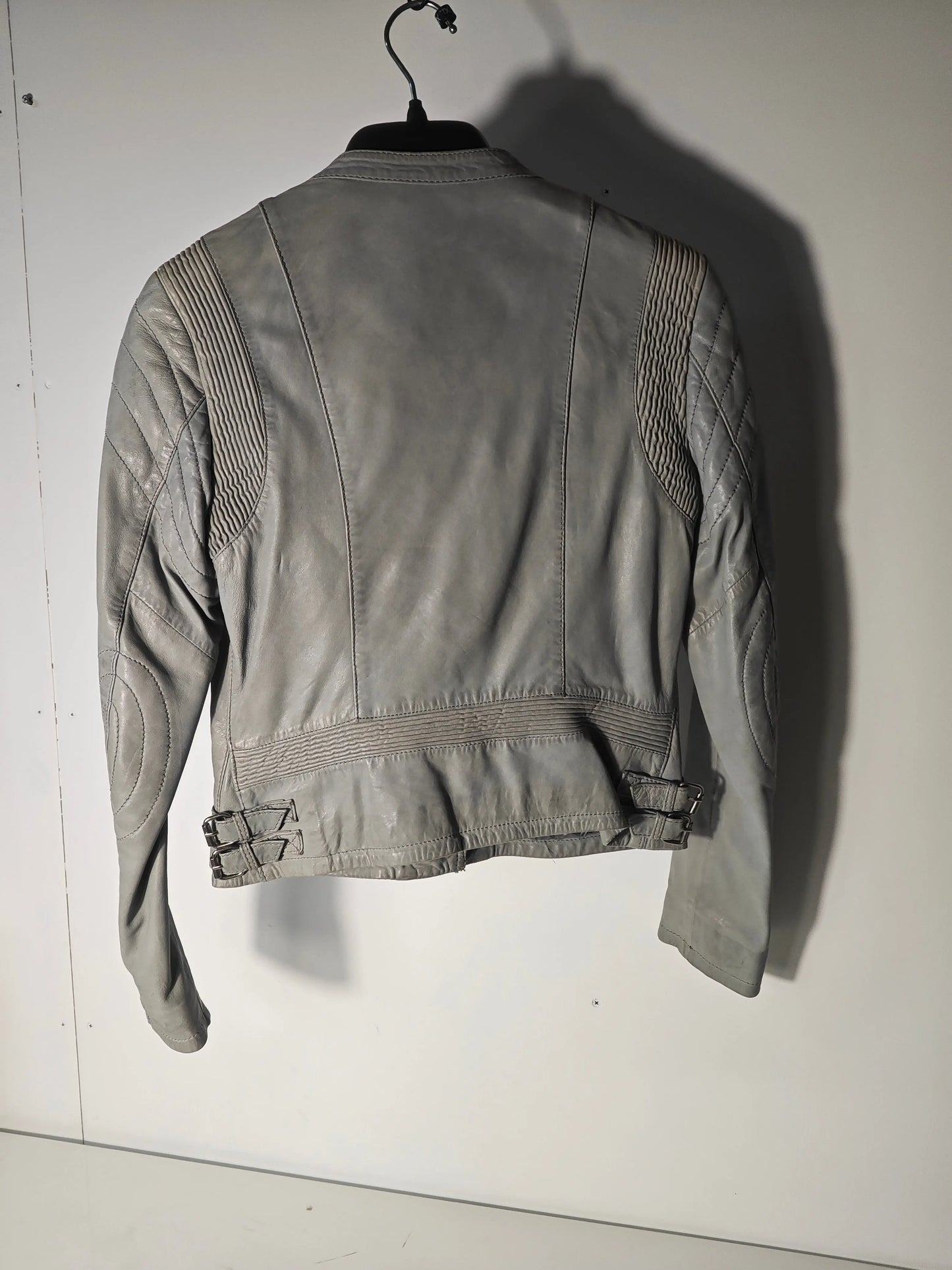 Veste en cuir gris de Giorgio & Mario, avec des détails matelassés sur les épaules et des boucles à la taille.