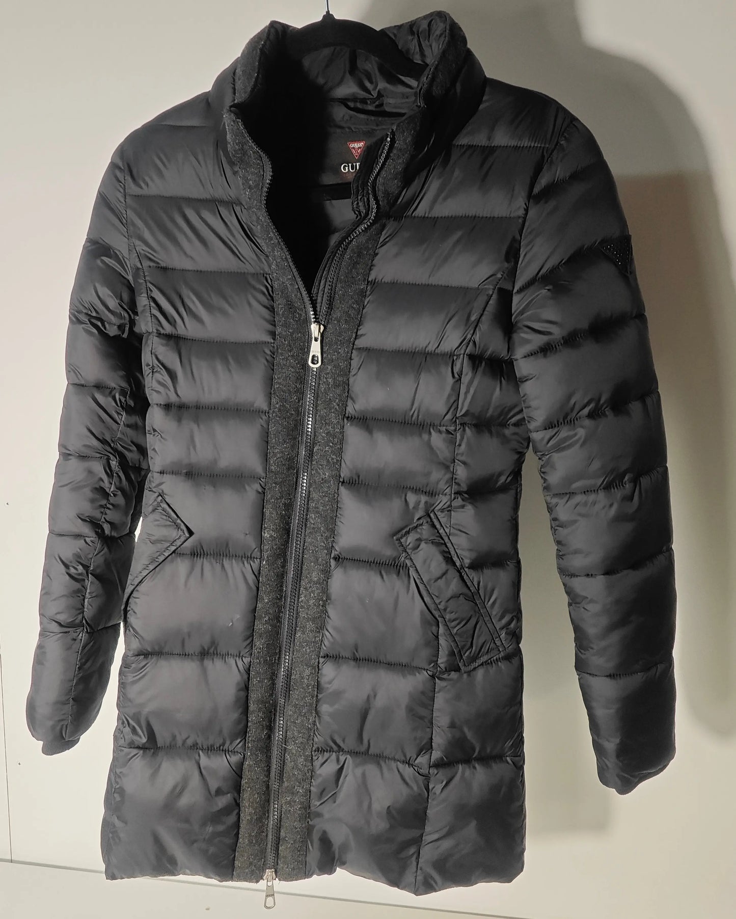 Doudoune longue noire de Guess avec col montant en laine grise, fermeture éclair et poches.