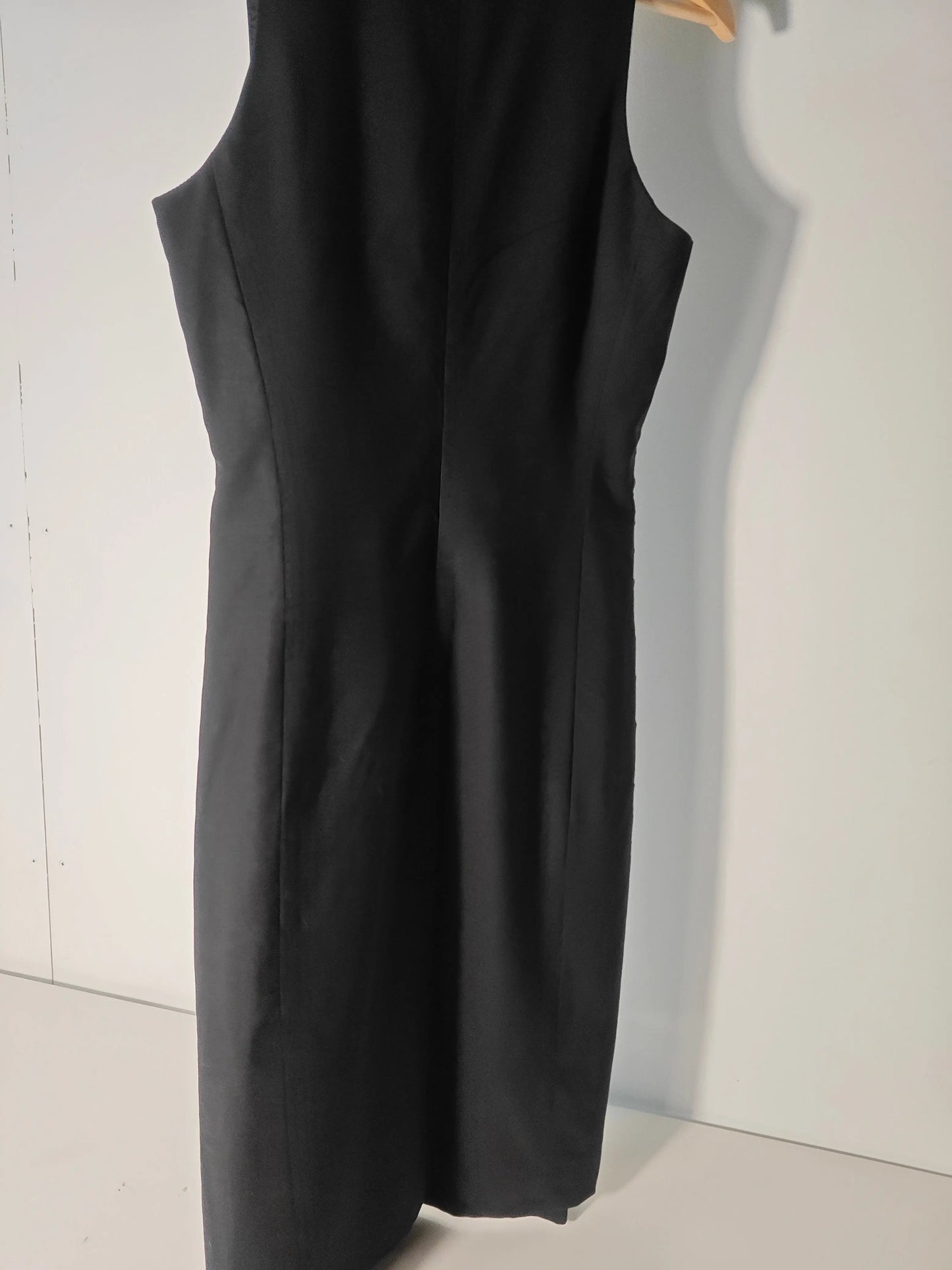 Robe noire sans manches de Theory, coupe ajustée, sur un cintre en bois.