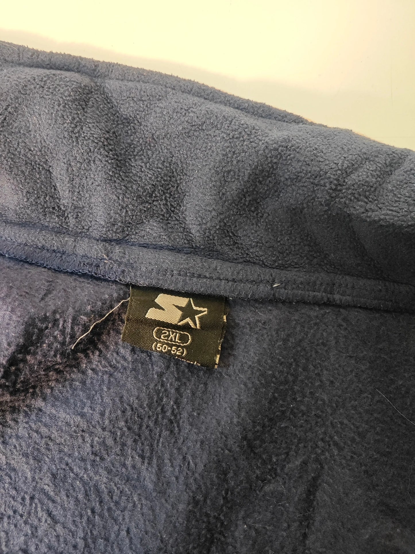 Veste polaire bleu marine de Skechers, taille 2XL, avec un empiècement gris et une étiquette de taille visible.