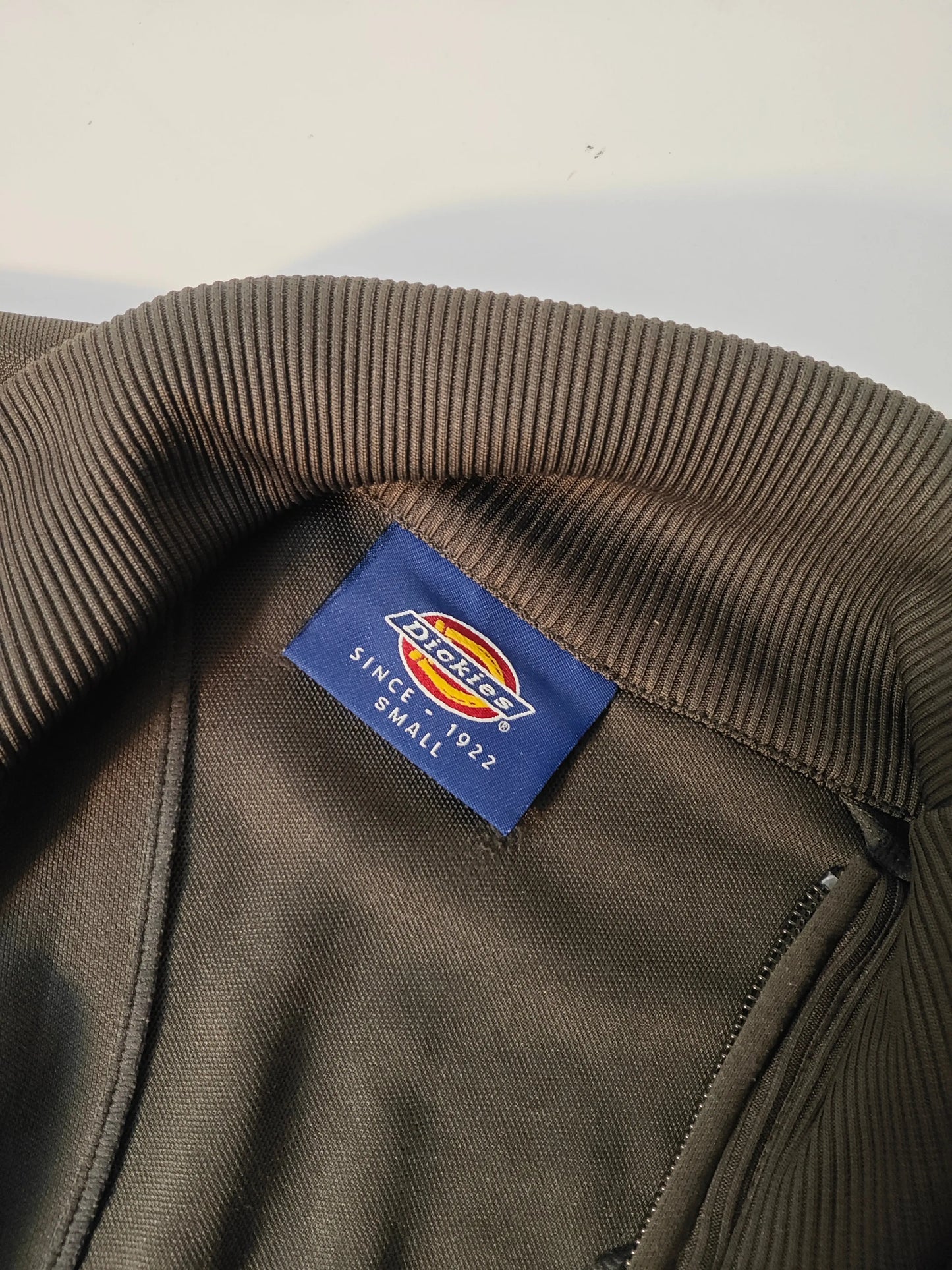 Veste sweat zippée marron de Dickies, col côtelé et étiquette de la taille visible.
