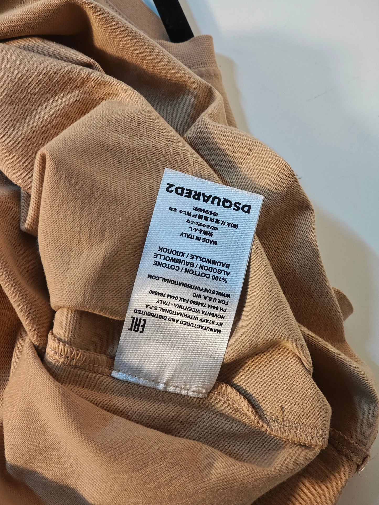 T-shirt beige en coton Dsquared2, avec étiquette d'entretien visible.