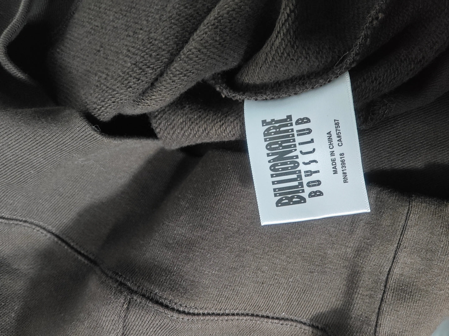 Sweat à capuche marron de Billionaire Boys Club, avec étiquette de la marque visible.