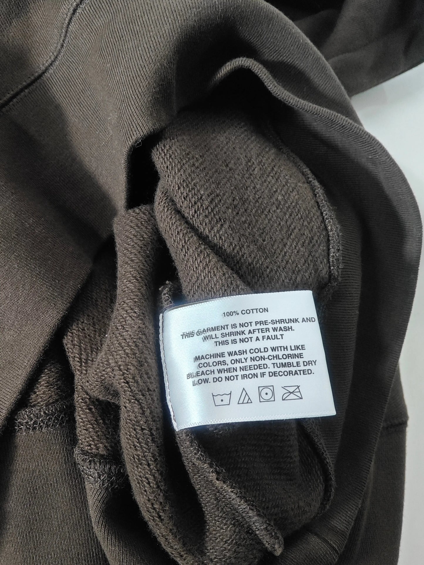 Sweat à capuche marron de Billionaire Boys Club avec étiquette d'entretien visible.