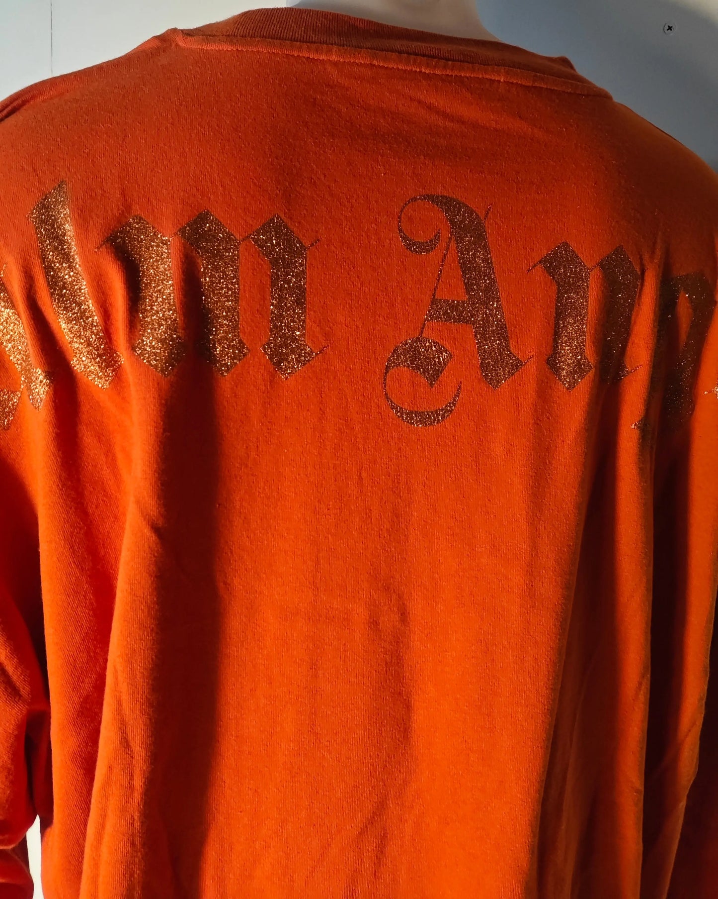 T-shirt orange oversize de Palm Angels, avec inscription scintillante sur le dos.
