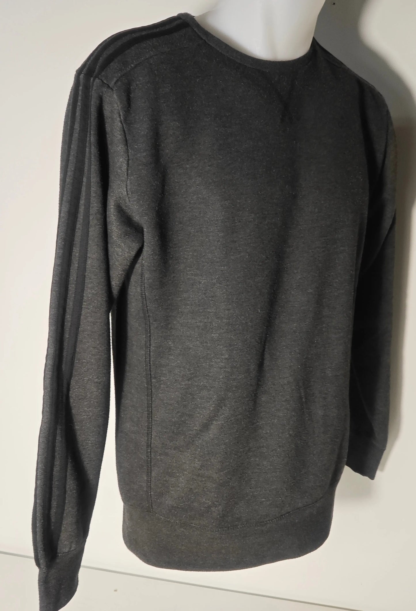 Sweat-shirt gris Sport Essentials de Adidas, avec trois bandes noires sur les manches longues.