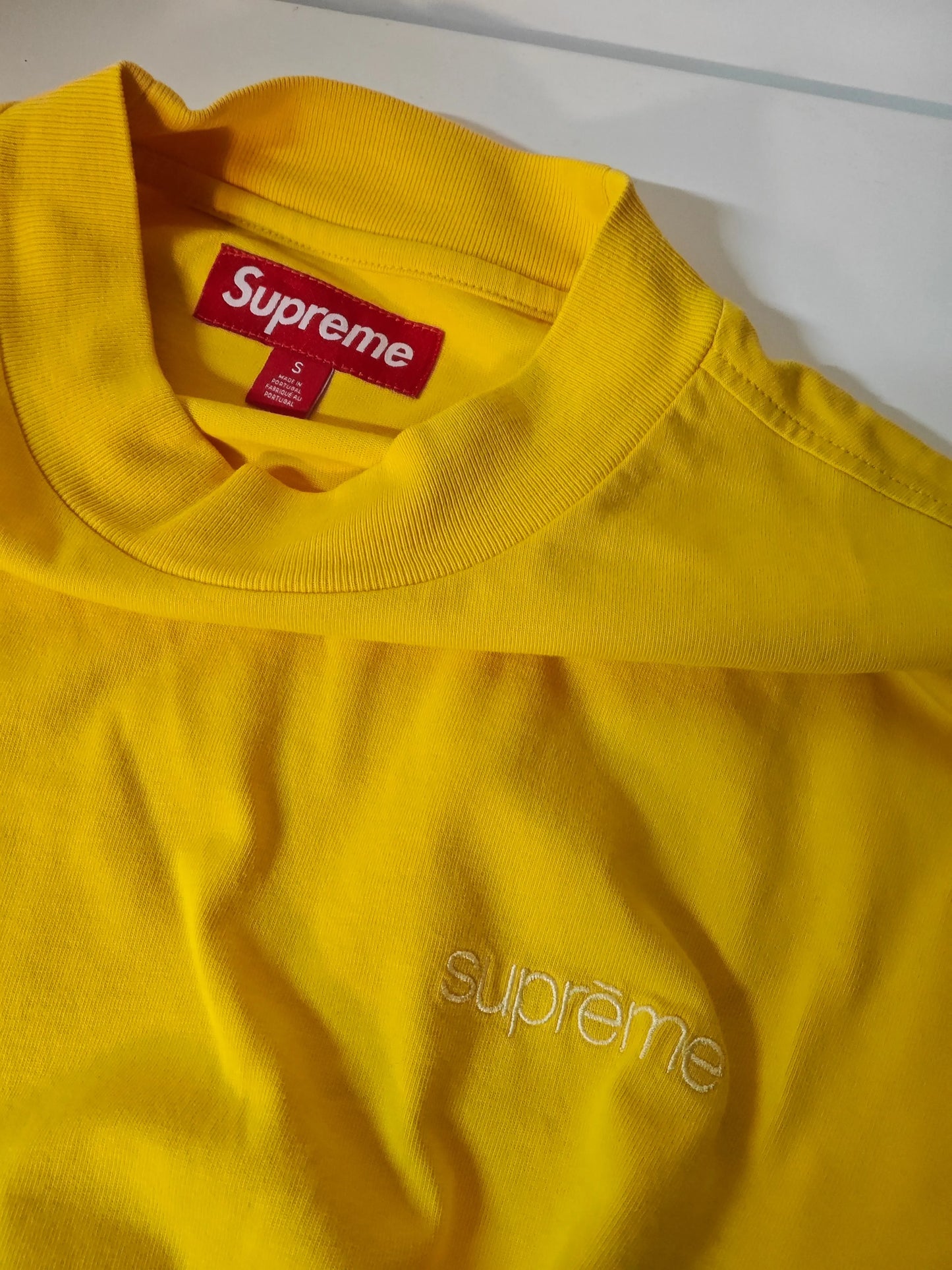 T-shirt manches longues jaune, de Supreme, avec logo brodé ton sur ton et étiquette rouge sur le col.