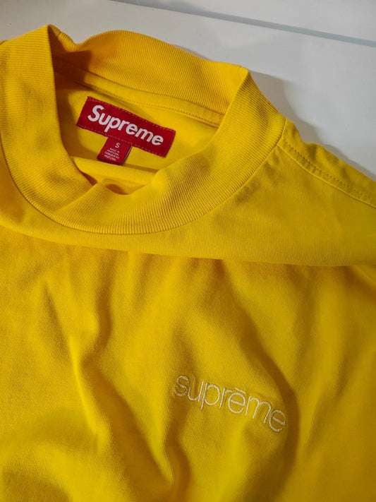 T-shirt manches longues jaune, de Supreme, avec logo brodé ton sur ton et étiquette rouge sur le col.