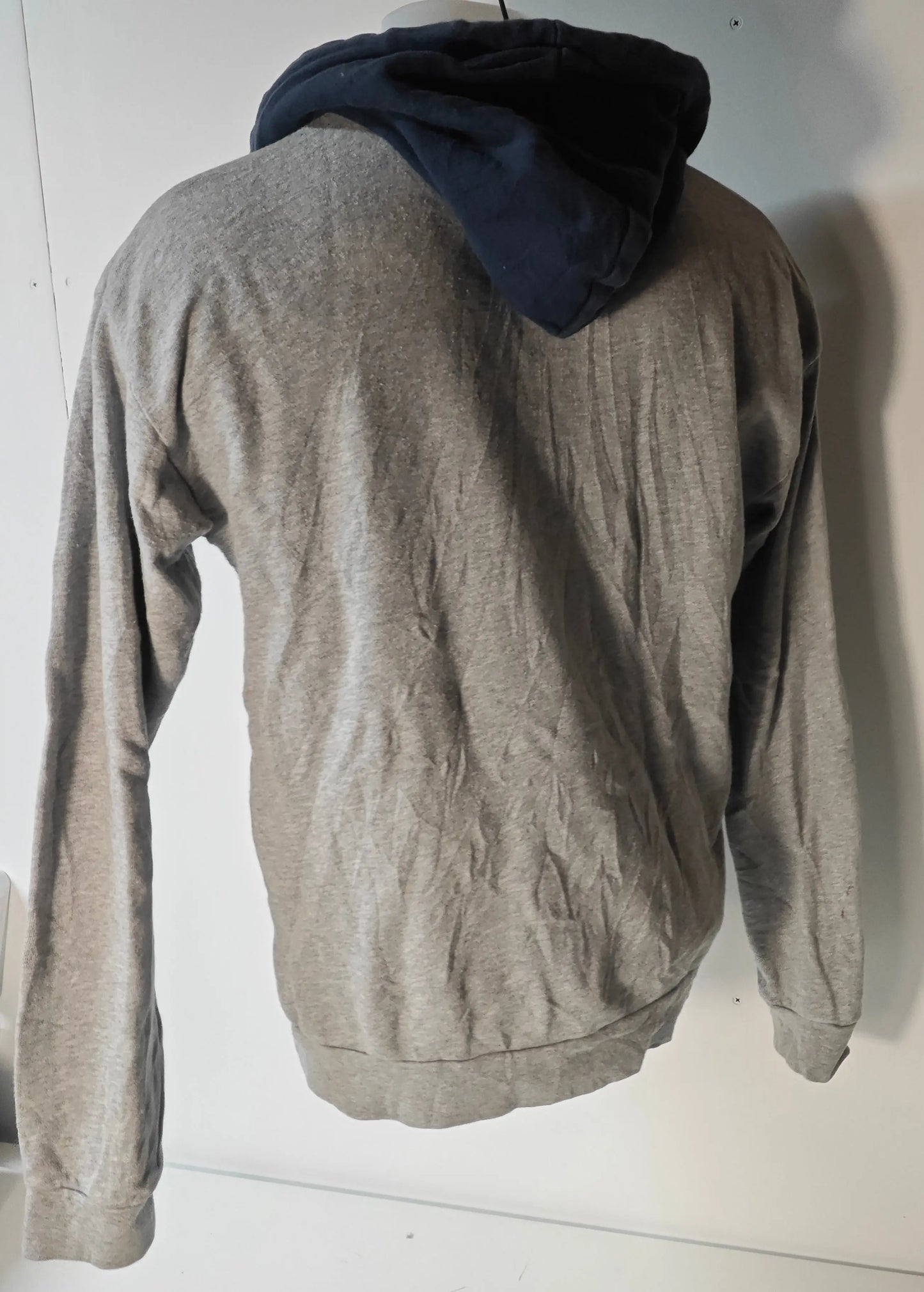 Sweat à capuche gris et bleu marine de Stüssy, vue de dos, avec capuche doublée bleu marine.