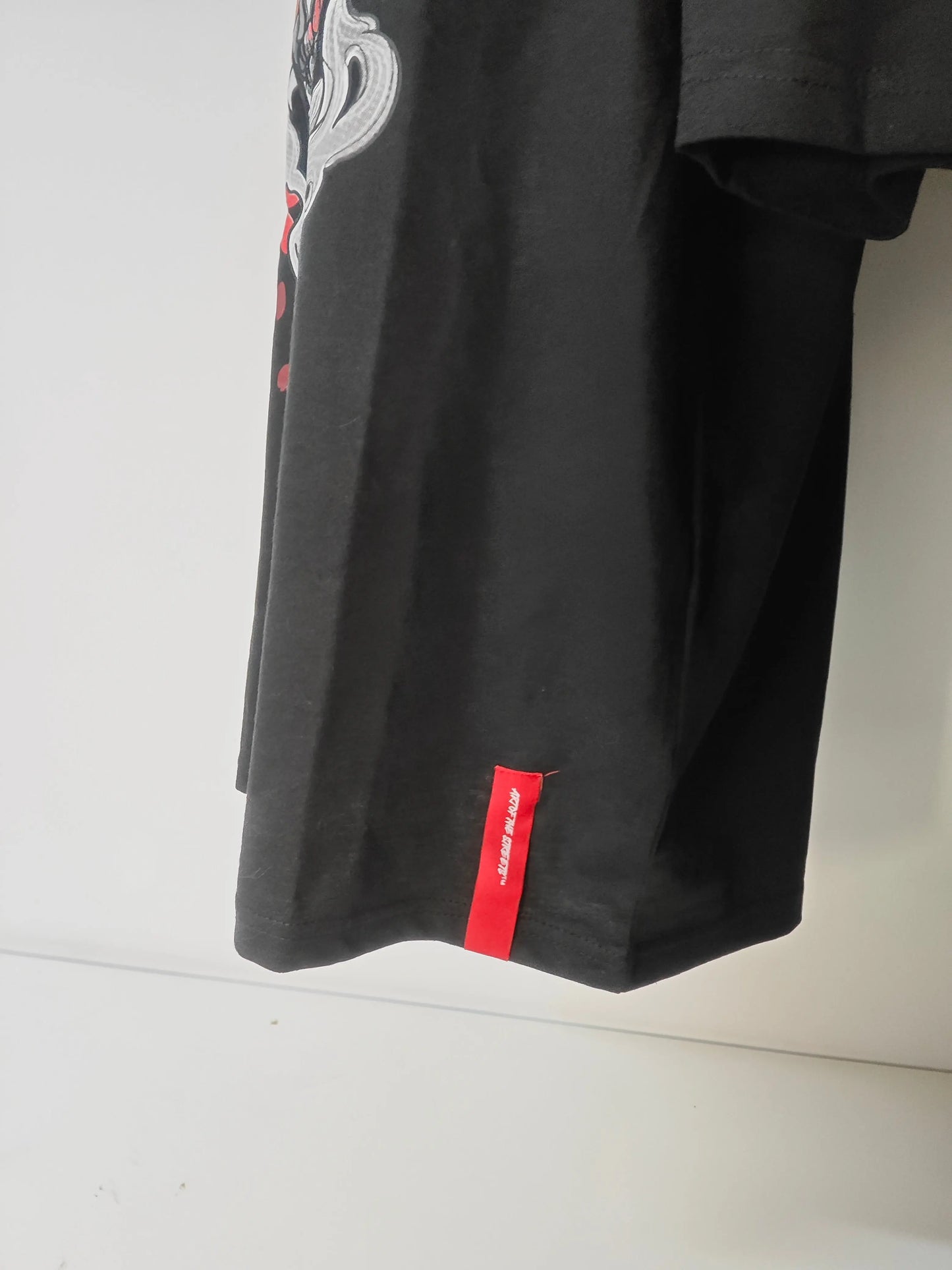 T-shirt noir Art of the Streets, avec un motif de masque japonais sur le côté.