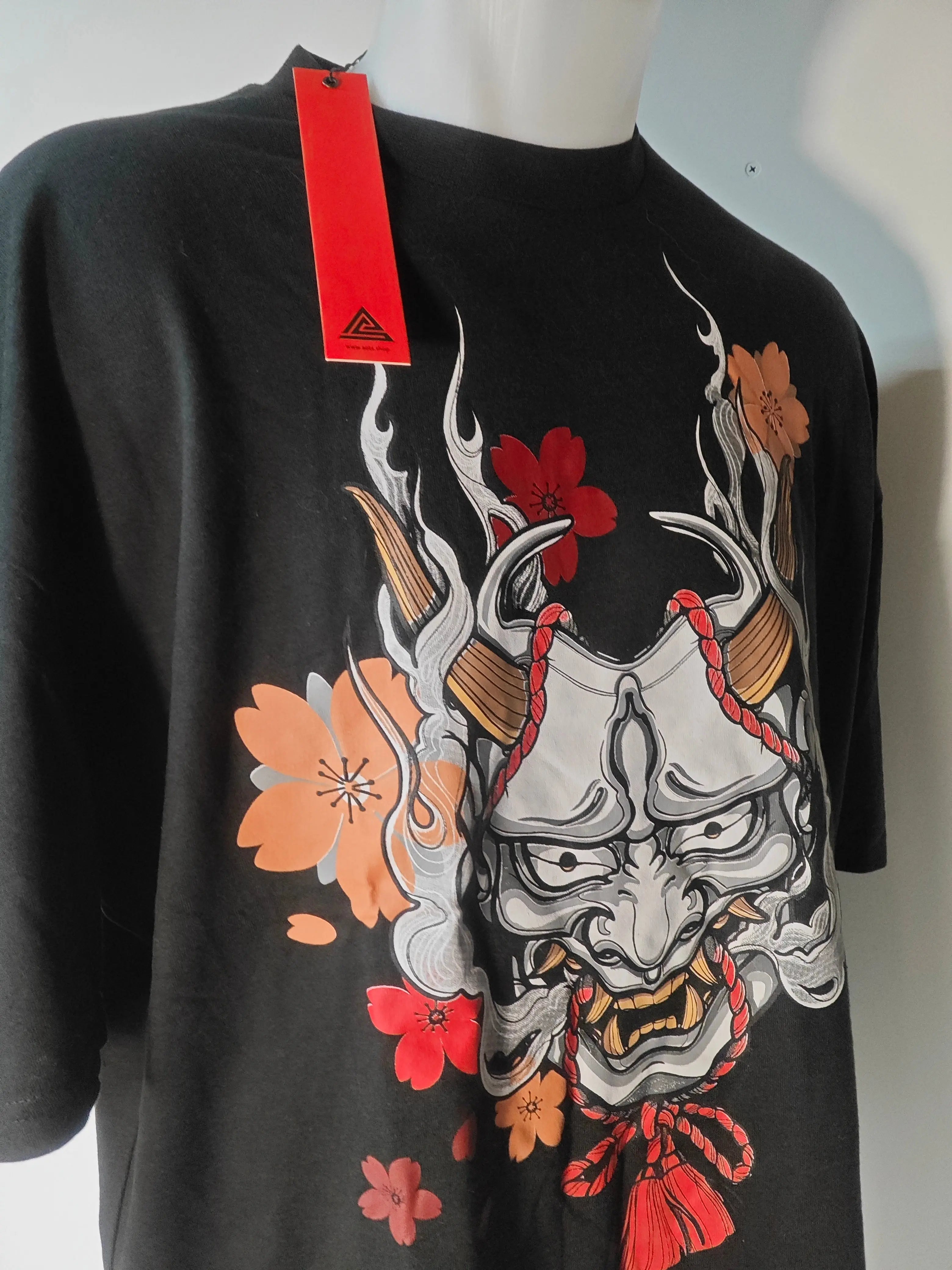 T-shirt noir Art of the Streets, avec un masque japonais orné de fleurs rouges et orange.
