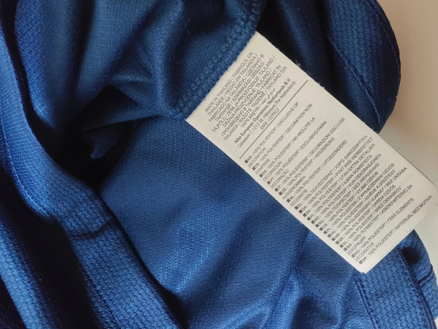 Maillot de foot bleu en Dri-Fit, de Nike, avec étiquette d'entretien visible.
