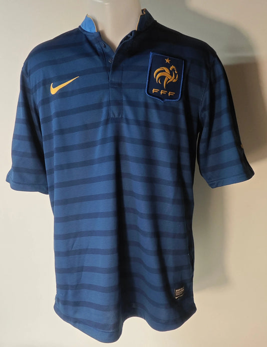 Maillot bleu marine de l'équipe de France FFF, Nike Dri-Fit, avec rayures horizontales et écusson doré.
