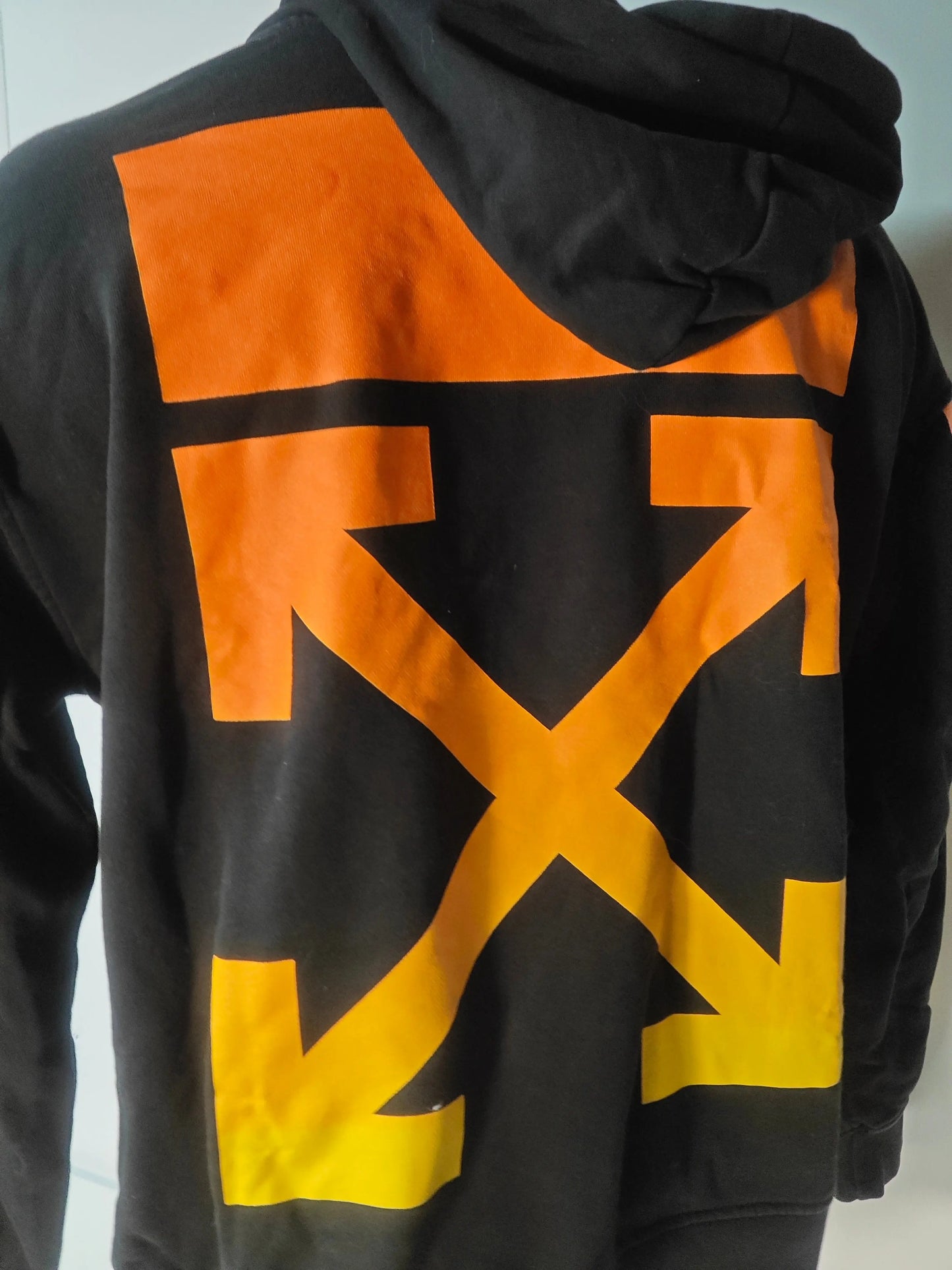 Sweat à capuche noir par Off-White avec grand motif fléché dégradé orange et jaune au dos.