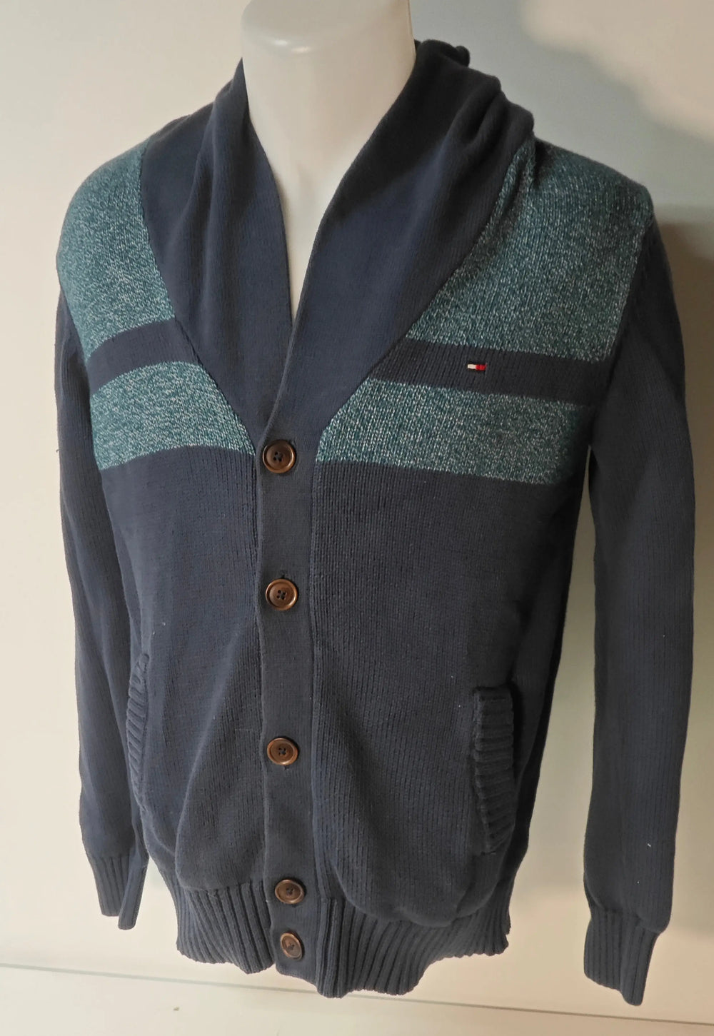 Cardigan bleu marine à boutons par Tommy Hilfiger, avec empiècements texturés vert turquoise sur le haut.