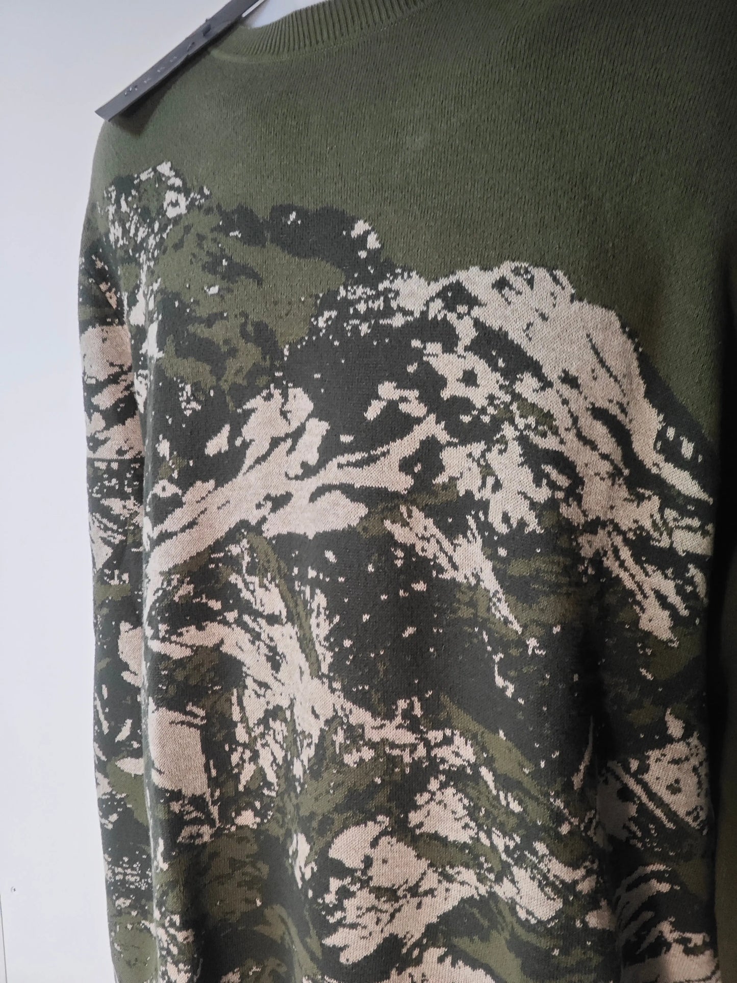 Pull IKKS camouflage en tricot vert et beige d'un motif abstrait.

