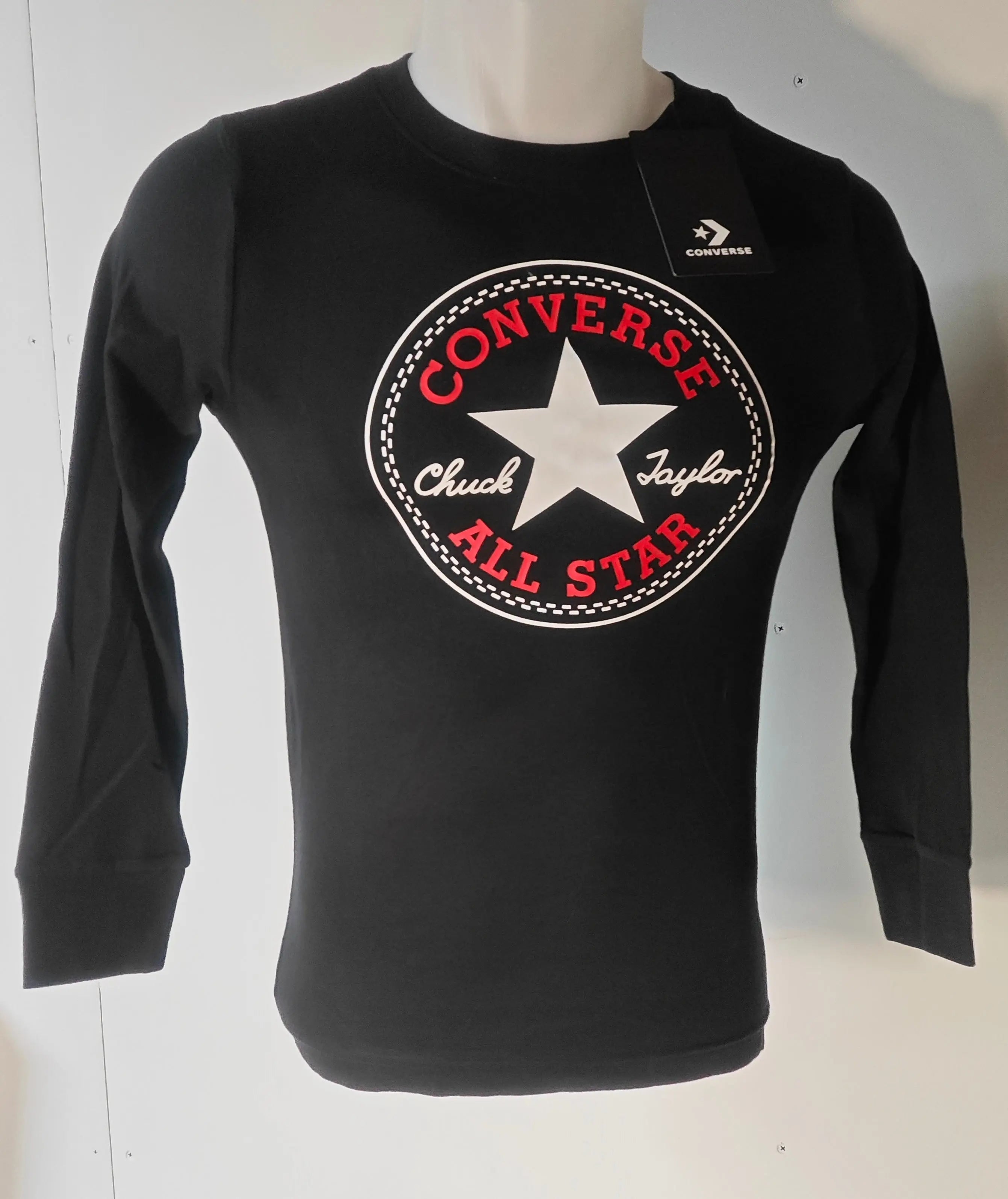 T-shirt noir à manches longues de Converse avec un grand logo rond sur le devant.
