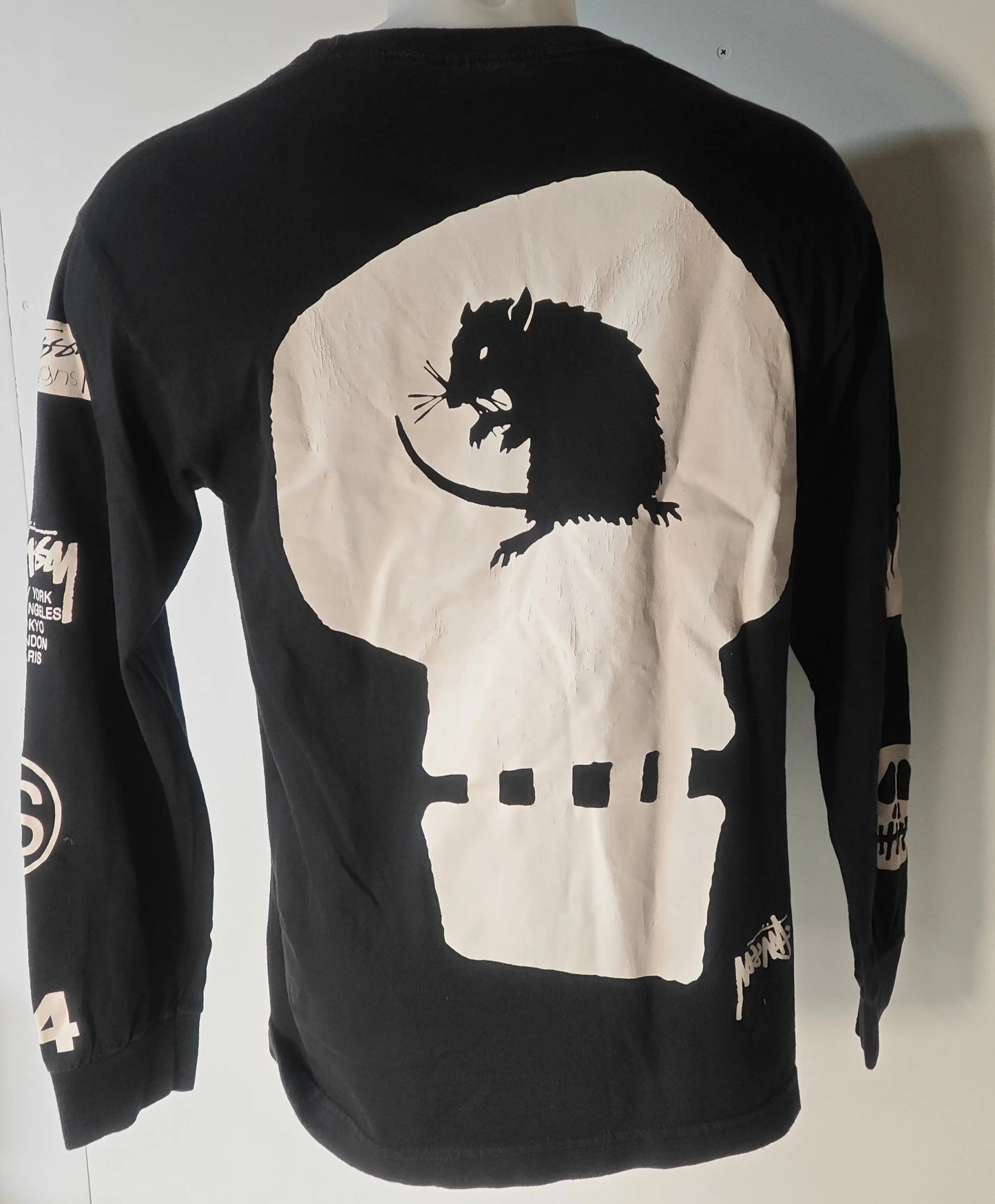 T-shirt noir à manches longues Stüssy, avec un motif de crâne et de rat au dos et des logos sur les manches.