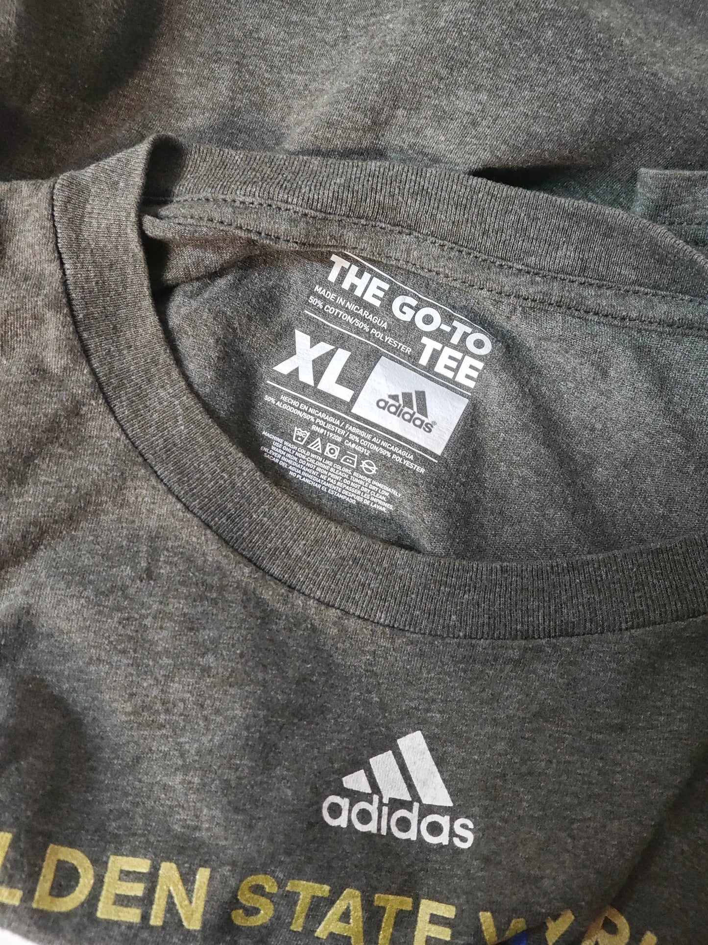T-shirt gris de taille XL par Adidas, avec le logo et le texte Golden State Warriors.