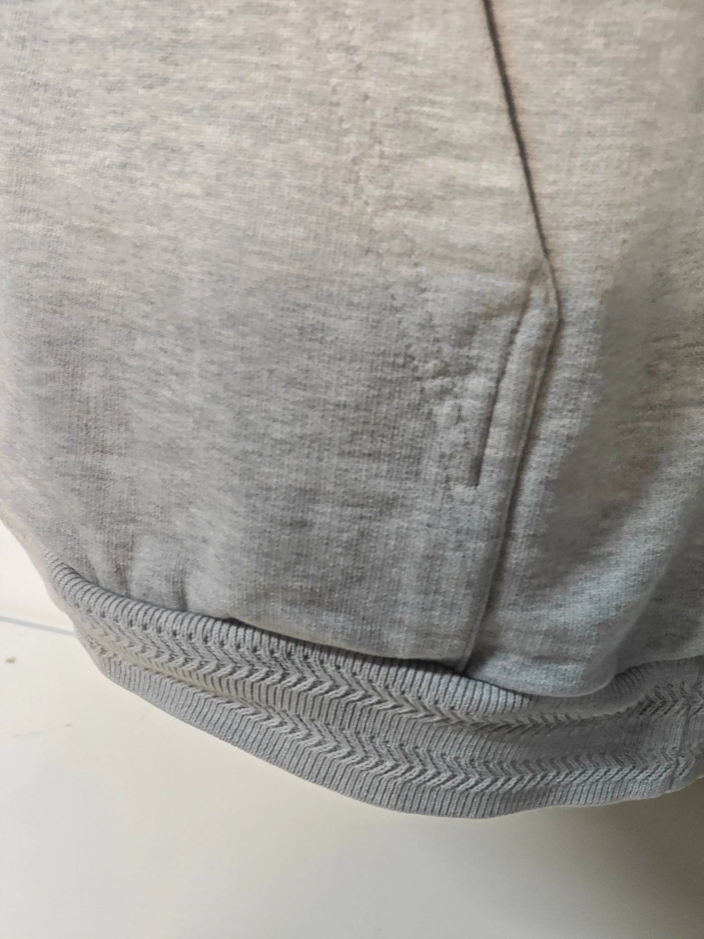 Sweat à capuche gris chiné de Drôle de Monsieur, avec un ourlet à chevrons et une texture douce.
