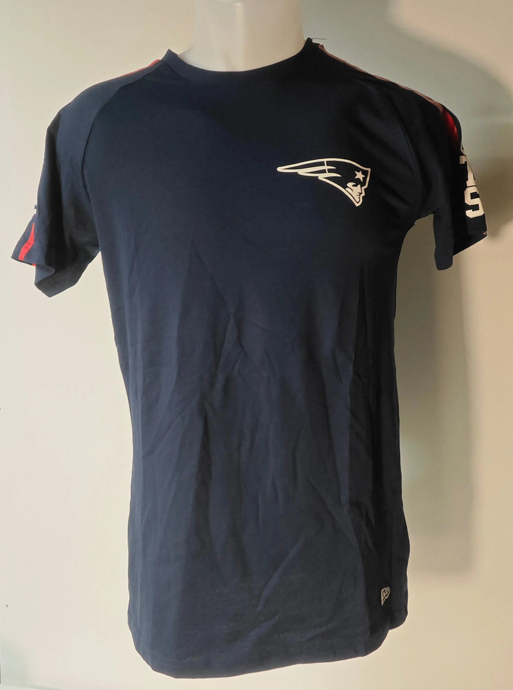T-shirt NFL bleu marine, New England Patriots, de New Era, avec logo sur la poitrine et détails rayés sur les manches.

