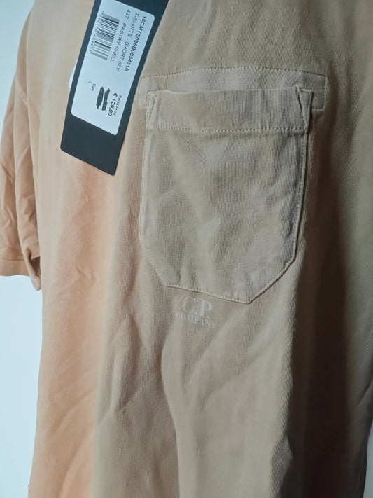 T-shirt beige en maille côtelée par C.P. Company, avec une poche poitrine et le logo de la marque en bas.
