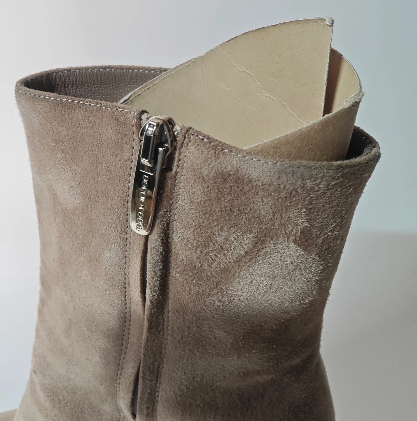 Bottines en daim taupe de Sergio Rossi avec fermeture éclair argentée et inserts de maintien en carton.
