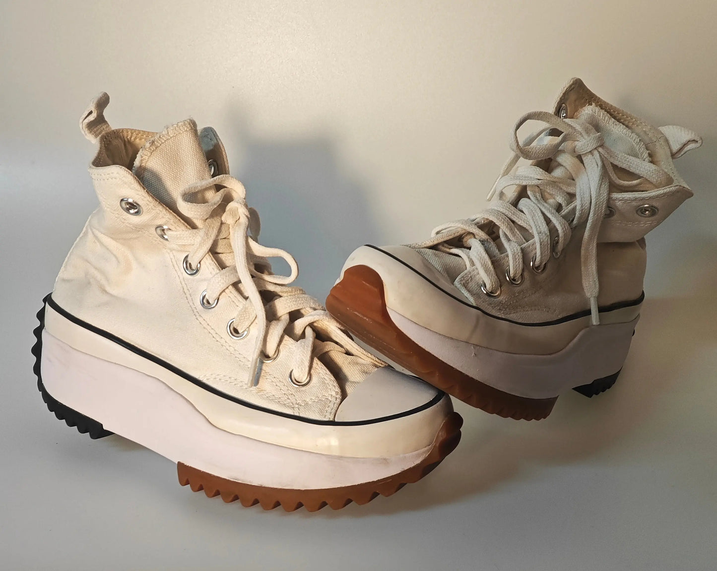 Baskets montantes crème de Converse, avec semelle compensée crantée noire et marron.