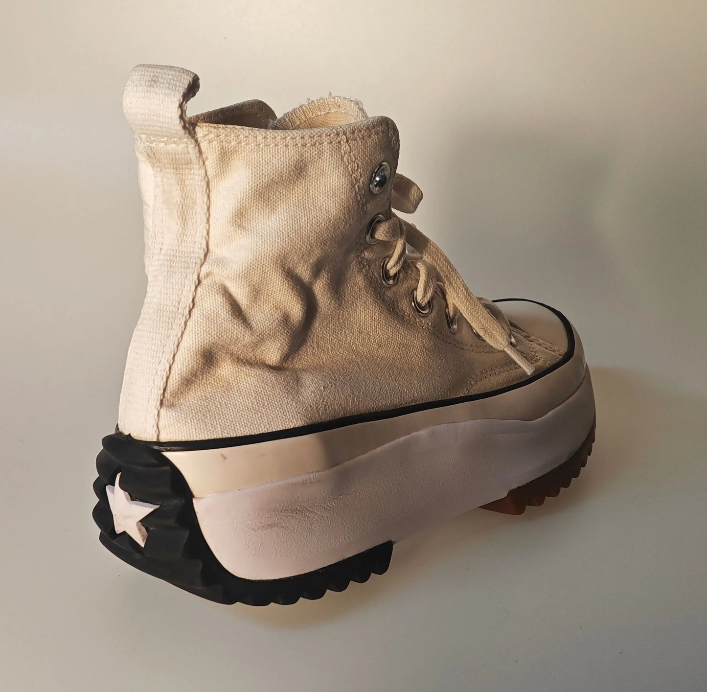 Basket montante crème et beige de Converse, avec une semelle plateforme crantée noire et blanche.
