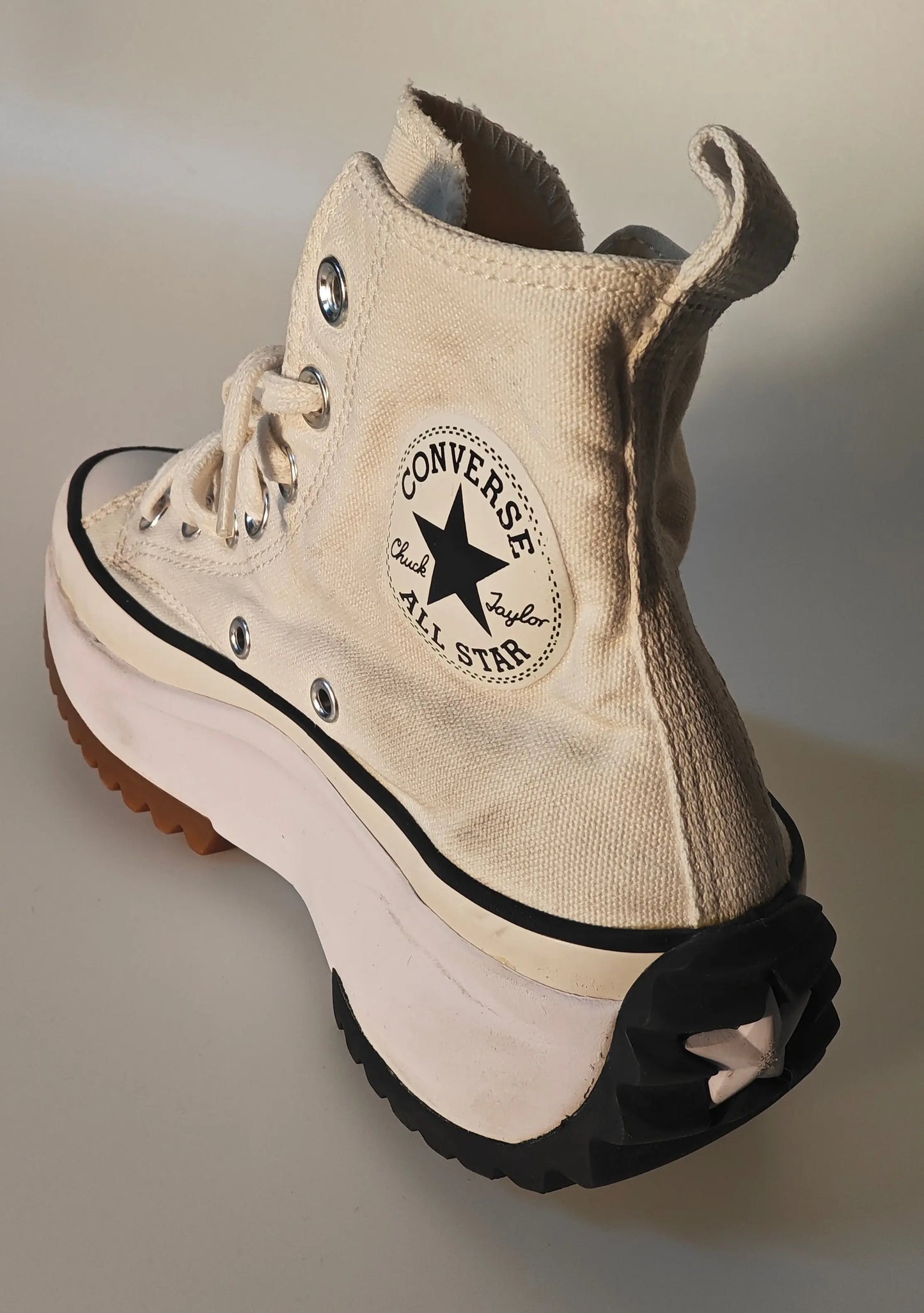 Basket montante crème de Converse avec semelle plateforme crantée noire et détails usés.
