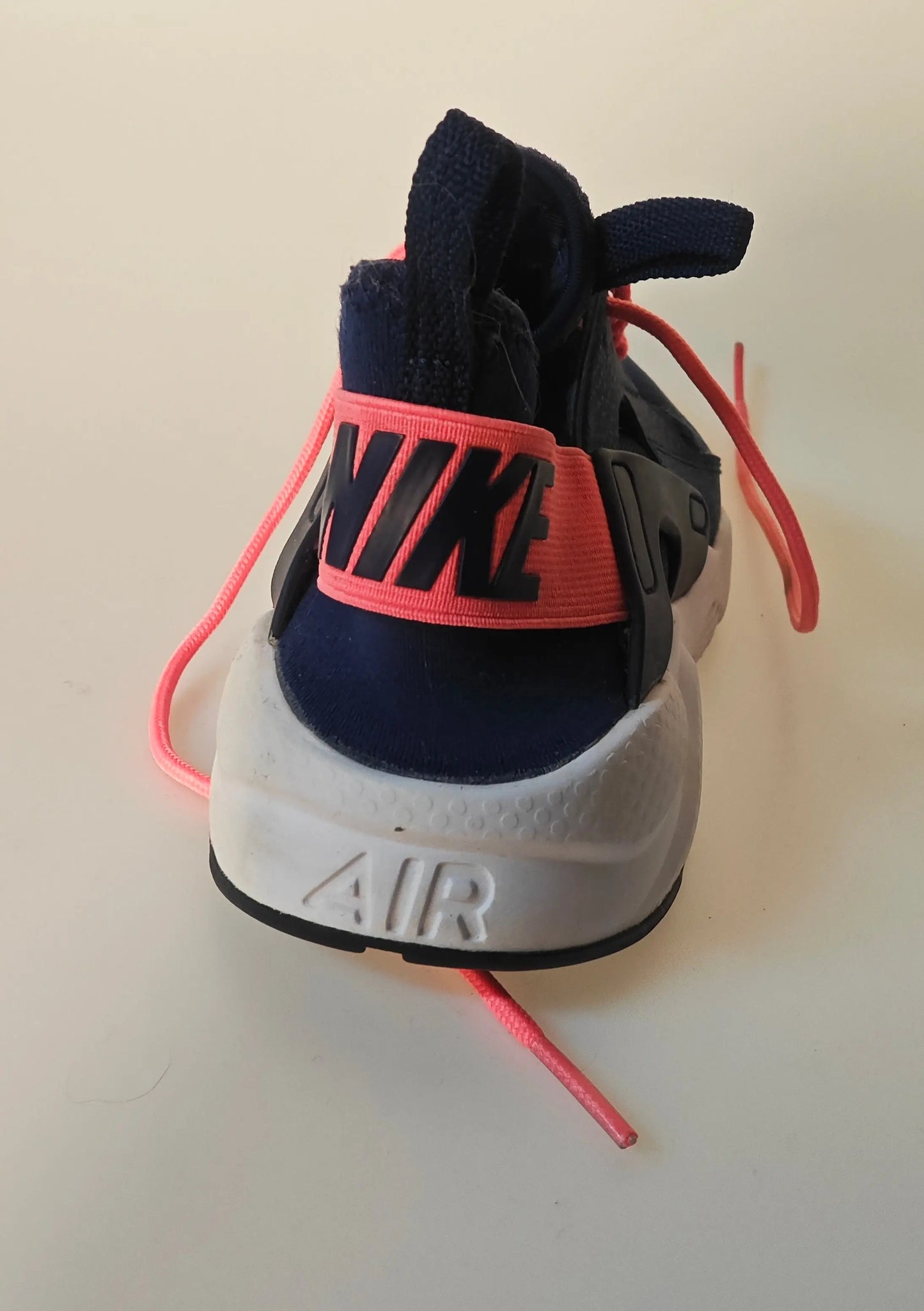Basket de course bleu marine et rose par Nike, vue arrière avec semelle blanche et lacets roses.
