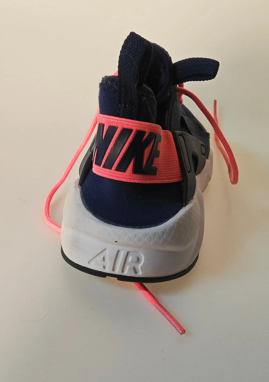 Basket de course bleu marine et rose par Nike, vue arrière avec semelle blanche et lacets roses.
