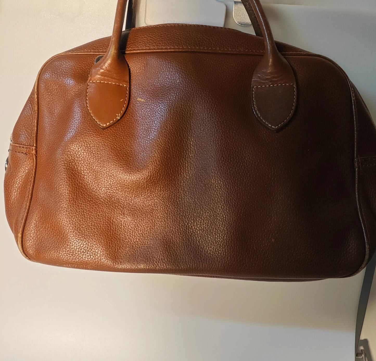 Sac Longchamp en cuir marron, authentique, par Longchamp, avec des détails élégants et une texture subtile.