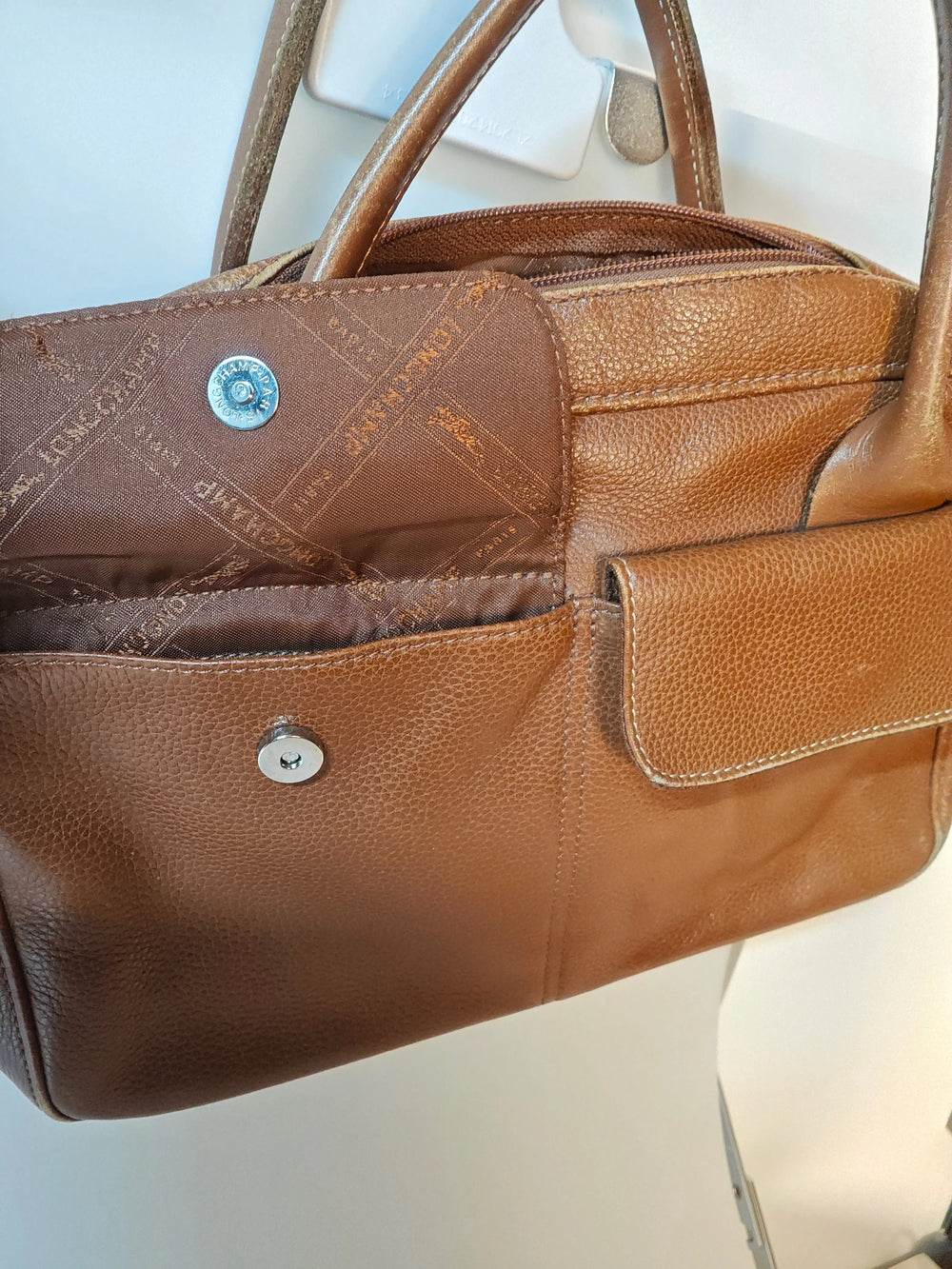 Sac Longchamp en cuir marron, authentique, de Longchamp, avec une poche extérieure et une fermeture à bouton pression.
