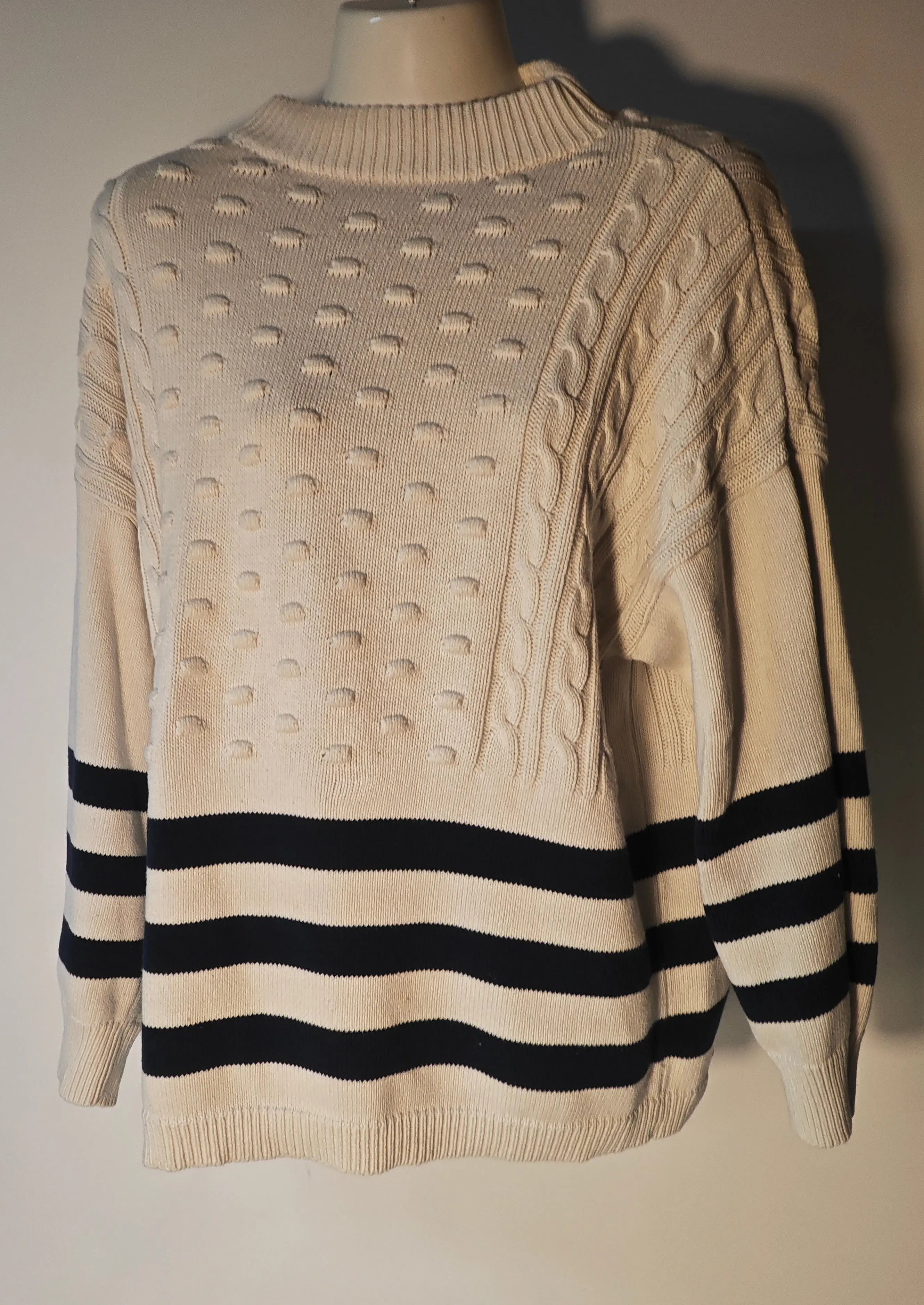 Pull Mango rayé blanc et marine de Mango, avec motif texturé et torsades décoratives.

