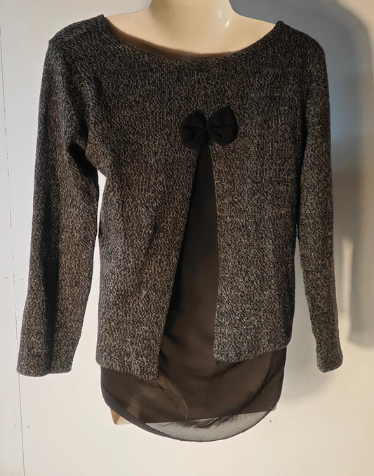 Top manches longues gris et noir de Upstyle Destock, avec un nœud décoratif sur le devant et un empiècement en mousseline noire.
