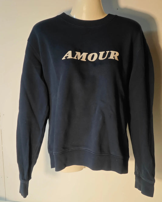Sweat bleu marine Sandro, avec le mot « AMOUR » en lettres blanches sur le devant, présenté sur un mannequin.
