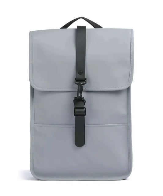Sac à dos gris Rains, avec une fermeture à clip en T noir sur le devant.