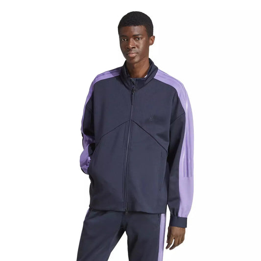 Veste de survêtement bleu marine et violet par Adidas, avec fermeture éclair complète et rayures décoratives sur les manches.