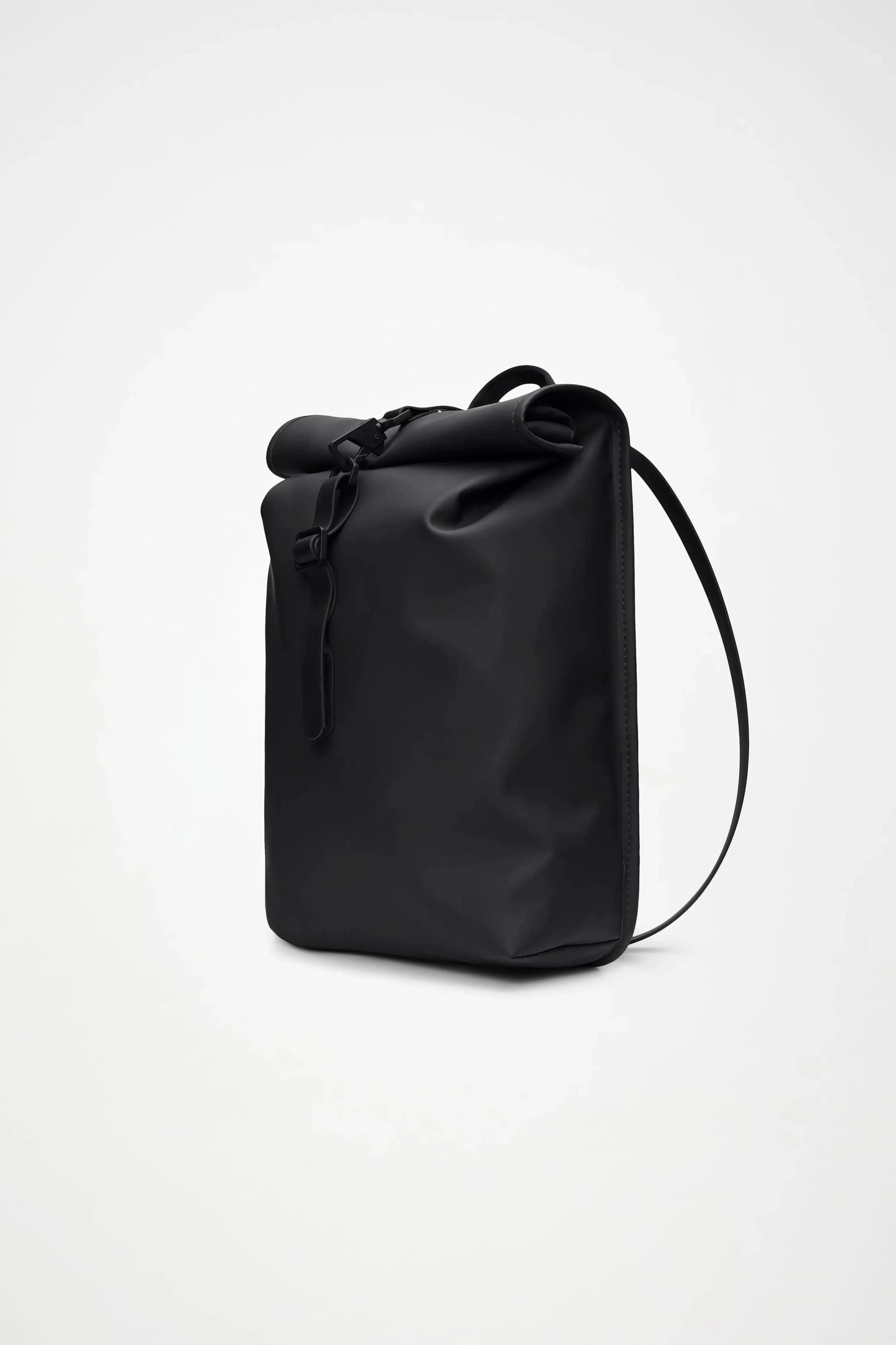 Sac à dos noir à enroulement de Rains, avec une bandoulière réglable et une fermeture à boucle.