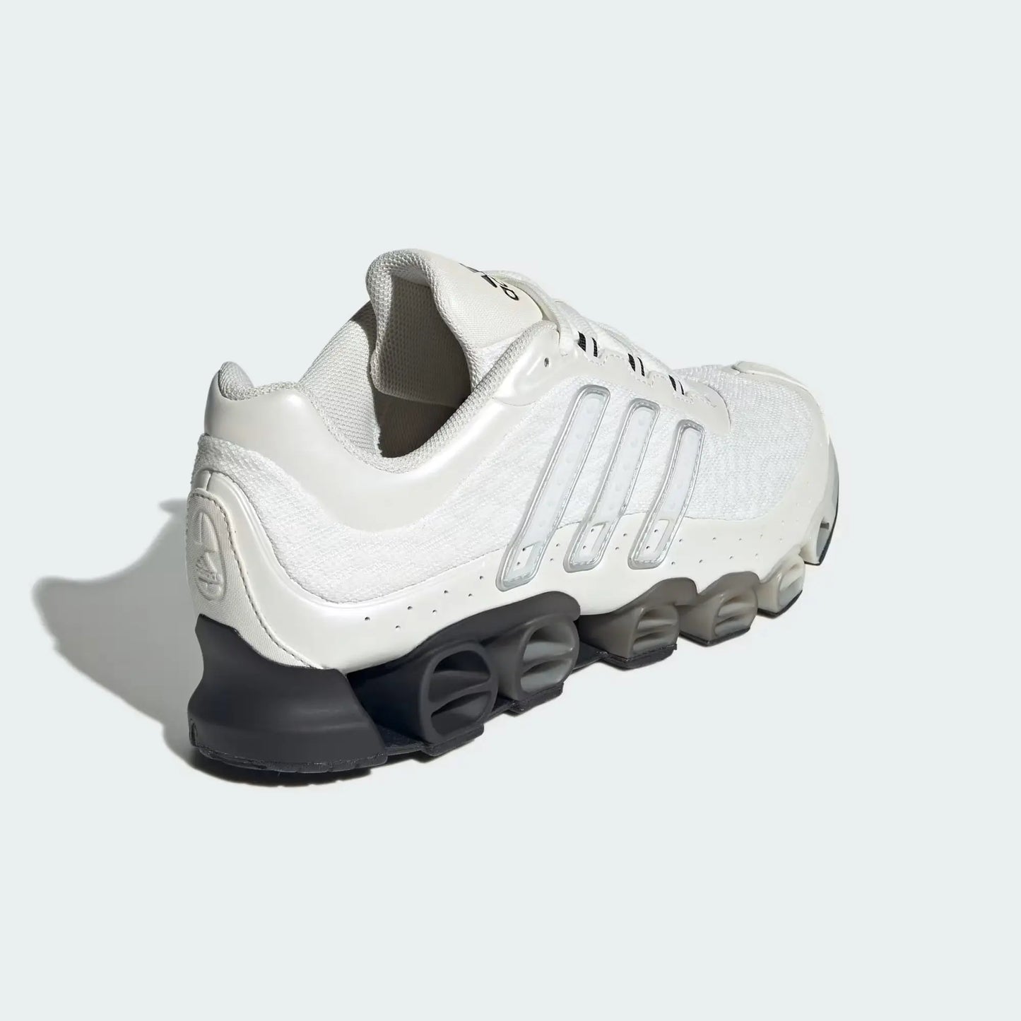 Chaussure de sport beige par Adidas, avec des rayures translucides et une semelle sculptée noire.