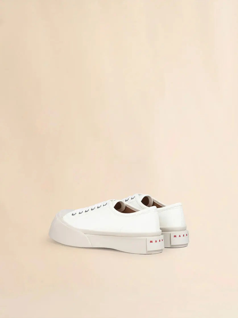 Baskets Marni Pablo en cuir nappa blanc de Marni, avec inscription rouge au talon, sur fond beige.
