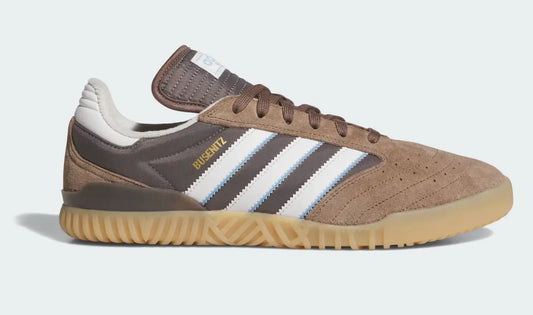 Baskets marron en daim par Adidas, avec rayures blanches et bleues et semelle extérieure en gomme, vue de côté.
