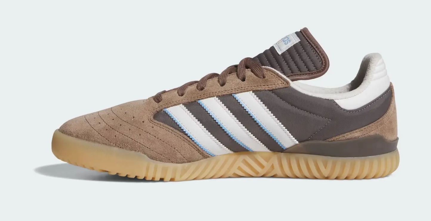 Chaussure de sport marron en daim d'Adidas avec trois rayures blanches et semelle texturée.