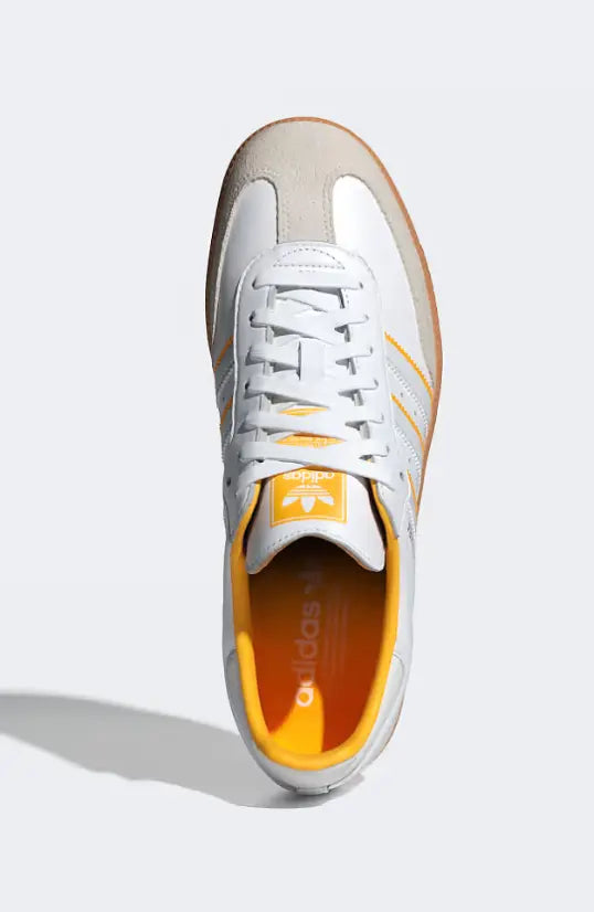 Baskets blanches Samba OG Adidas avec détails jaunes et semelle en gomme, vue de dessus.