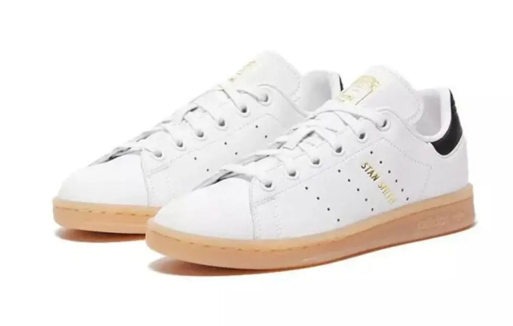 Baskets Stan Smith en cuir blanc, de Adidas, avec semelle en gomme et détails noirs au talon.
