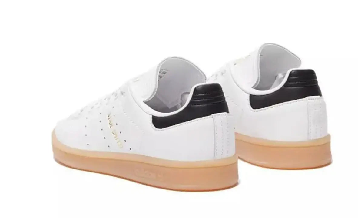 Sneakers en cuir blanc, par Adidas, avec contrefort arrière noir et semelle couleur gomme.