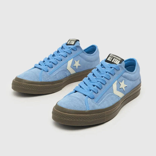 Baskets basses bleues en daim de Converse, avec étoile blanche et semelle marron.
