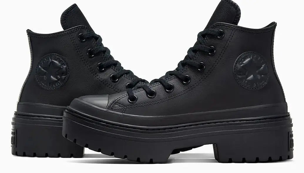 Baskets montantes noires à plateforme de Converse, avec logo rond ton sur ton sur le côté.
